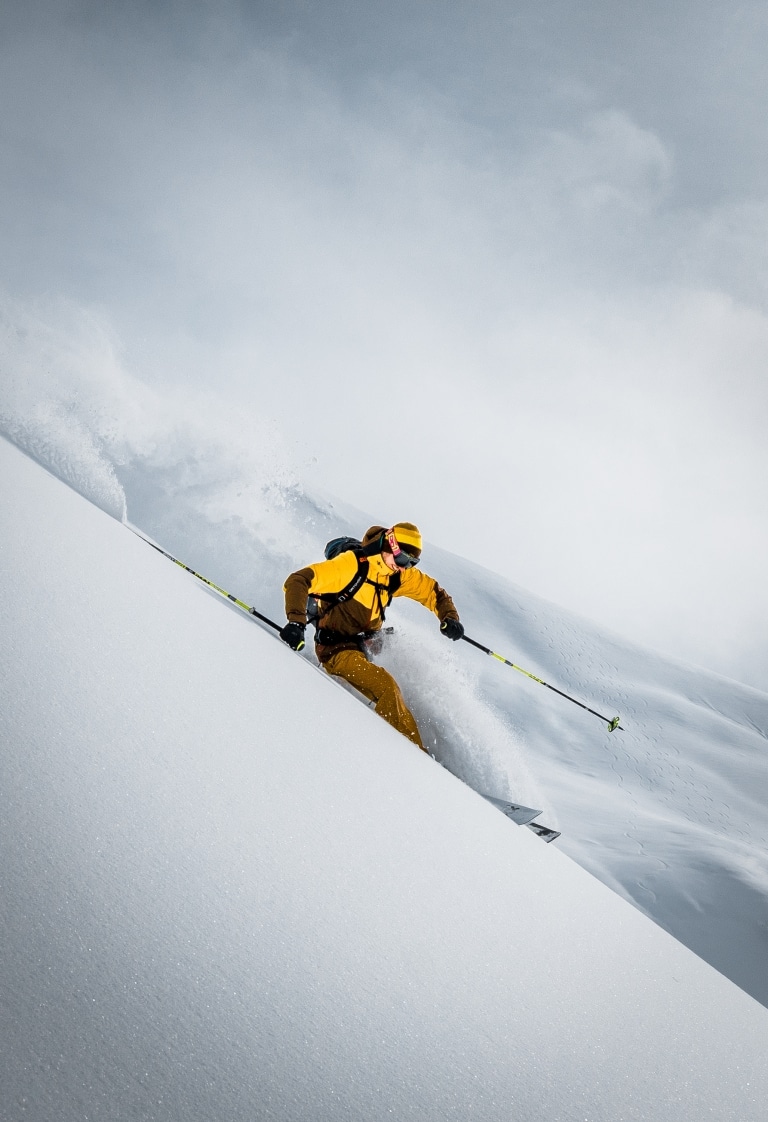 Symbolbild für Skiurlaub am Arlberg: Skifahrerin während einer Tiefschneeabfahrt in Lech