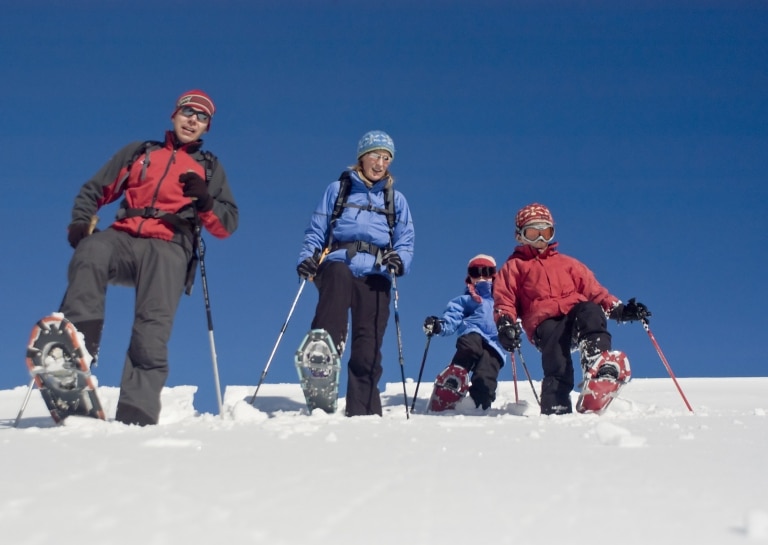 Symbolbild Schneeschuh Wandern Arlberg mit Kind: 4-köpfige Familie beim Schneeschuhwandern