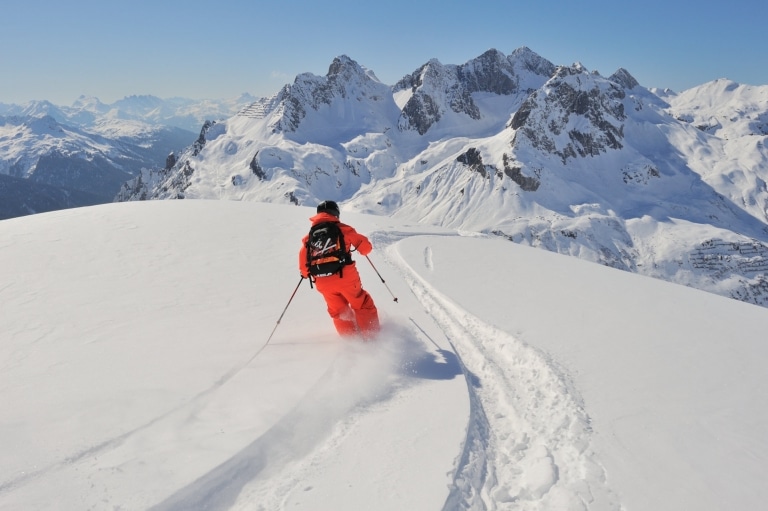 Symbolbild Freeriden Arlberg: Skifahrer fährt im Skiurlaub am Arlberg eine Tiefschneeabfahrt