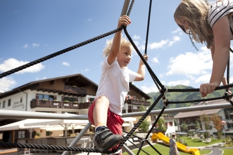 Sommerurlaub in Oberlech am Arlberg Zwei Kinder auf dem Klettergerüst beim Sommerlaub im Hotel Sonnenburg in Oberlech.