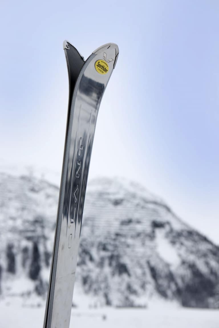 Symbolbild für Skiverleih Oberlech: Ski mit Logo des Skiverleih Sport Huber steck im Schnee