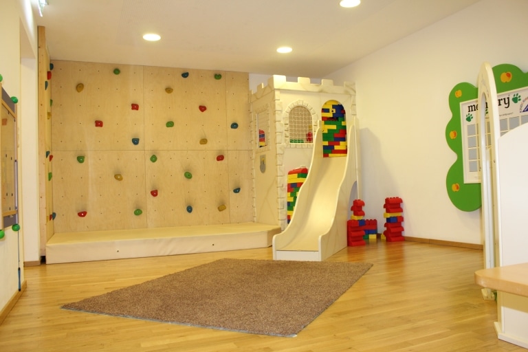 Urlaub mit Kinderbetreuung ab 3 Jahren zeigt Kletterwand im Spielzimmer des Familienhotel Sonnenburg