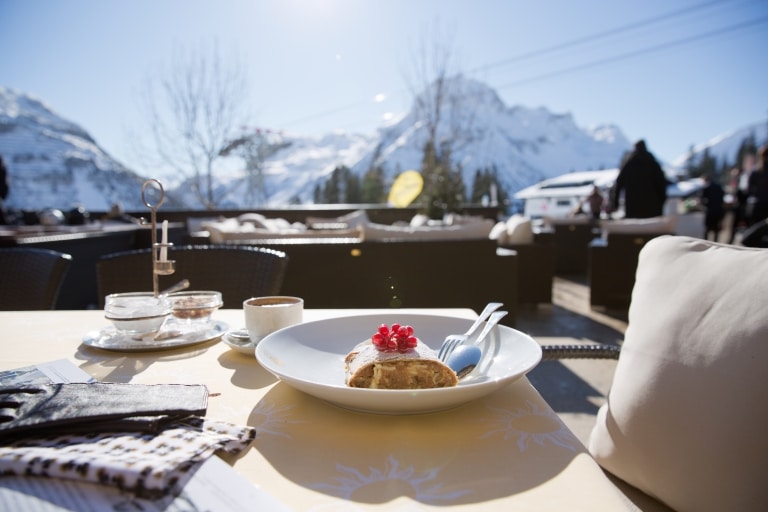 Zu Mittag speisen Sie auf der Sonnenterrasse der Sonnenburg typisch alpin, am Nachmittag servieren wir Ihnen hausgemachte Mehlspeisen mit einzigartiger Aussicht auf die majestätischen Gipfel des Arlbergmassivs.