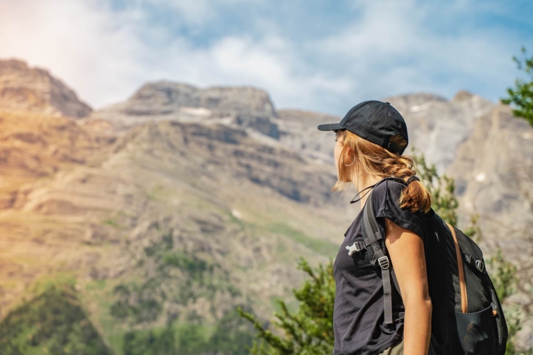 Teenagerin mit schwarzer Wanderkleidung blickt in die Berge beim Wandern