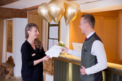 Benefits Job Österreich Symbolbild für Benefits im Job in Österreich: HR-Mitarbeiterin überreicht Gutscheine