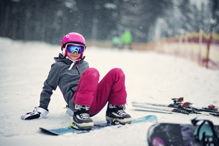 Ein Kind auf dem Snowboard in Lech