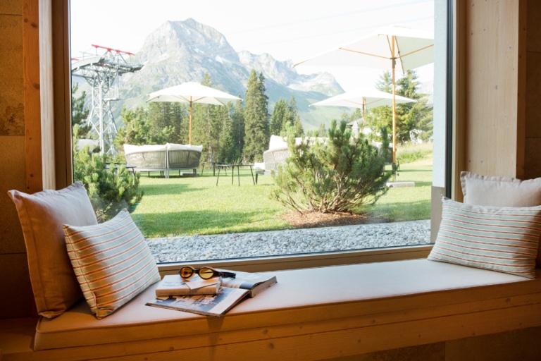 Fensterplatz mit Kissen und Blick auf Alpenpanorama