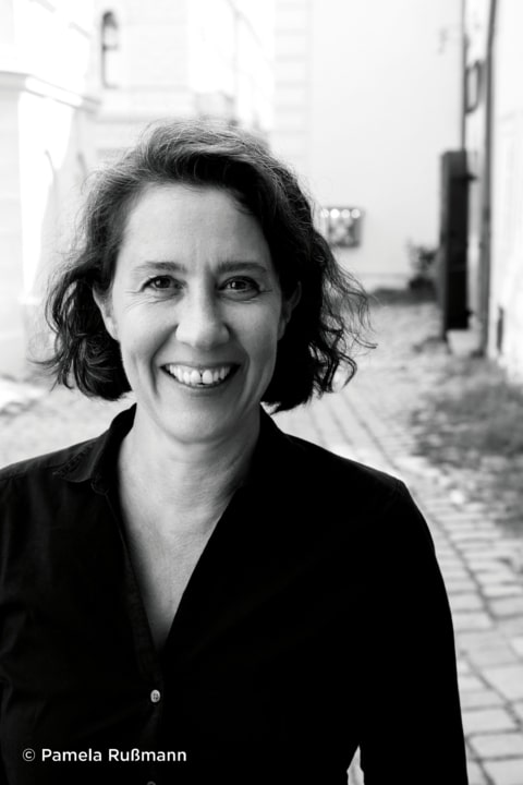 Petra Hartlieb Professionelle Portraitaufnahme einer Expertin im Bereich Tourismus und Gastronomie, lächelnd in einer urbanen Kulisse.