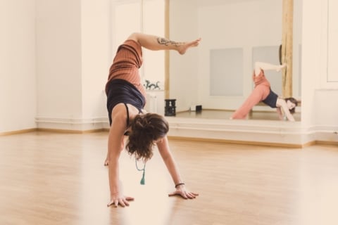 Claudia Galos Bild 3 2024 Frau in Handstandübung in einem modernen Yogastudio
