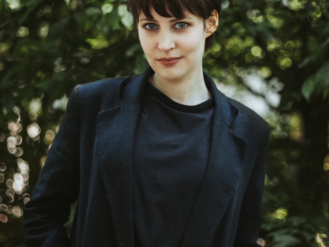 Bell.Theresa_Lueck.Wiebke Professionelle junge Frau im Freien vor grüner Kulisse, symbolisiert Gastronomie- und Tourismusbranche