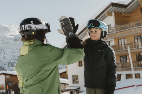 Skitag (c) Dominic Kummer Skilehrerin gibt einem Mädchen ein High-Five