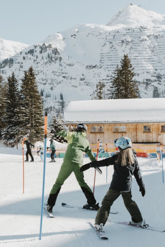 Skilehrerin mit Kind beim Kurven-Training