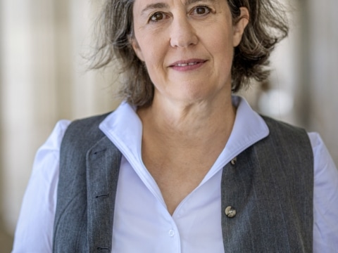 ©Ulrik Hölzel_klassisch Portrait der Autorin Petra Hartlieb mit Blauser Hemdluse bei Tageslicht vor einem Gebäude